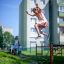 Pige hopper fra balancebom på legepladsen.